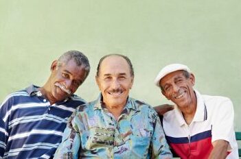 Alzheimer's disease study image with 3 elderly men smiling against a green background.
